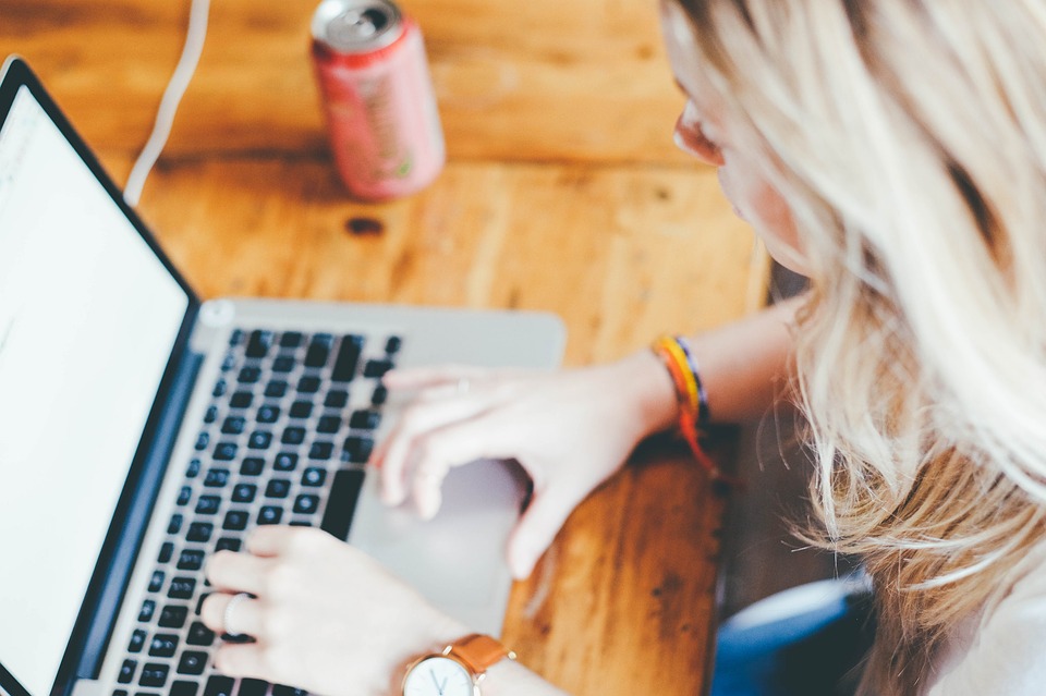 blond girl working on a laptop